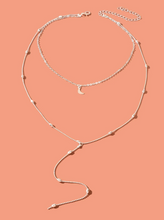 Charger l&#39;image dans la galerie, Un collier à plusieurs rangs avec un pendentif en forme de lune à breloque
