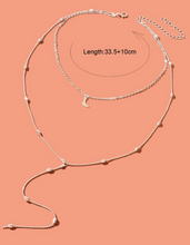 Charger l&#39;image dans la galerie, Un collier à plusieurs rangs avec un pendentif en forme de lune à breloque
